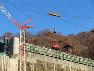 画像：18t吊りケーブルクレーンで重機を運搬する様子